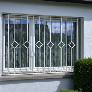 Fenstergitter mit Staketen und Karo-Ornamente